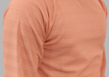Close-up of a peach-colored textured fabric garment on a gray background