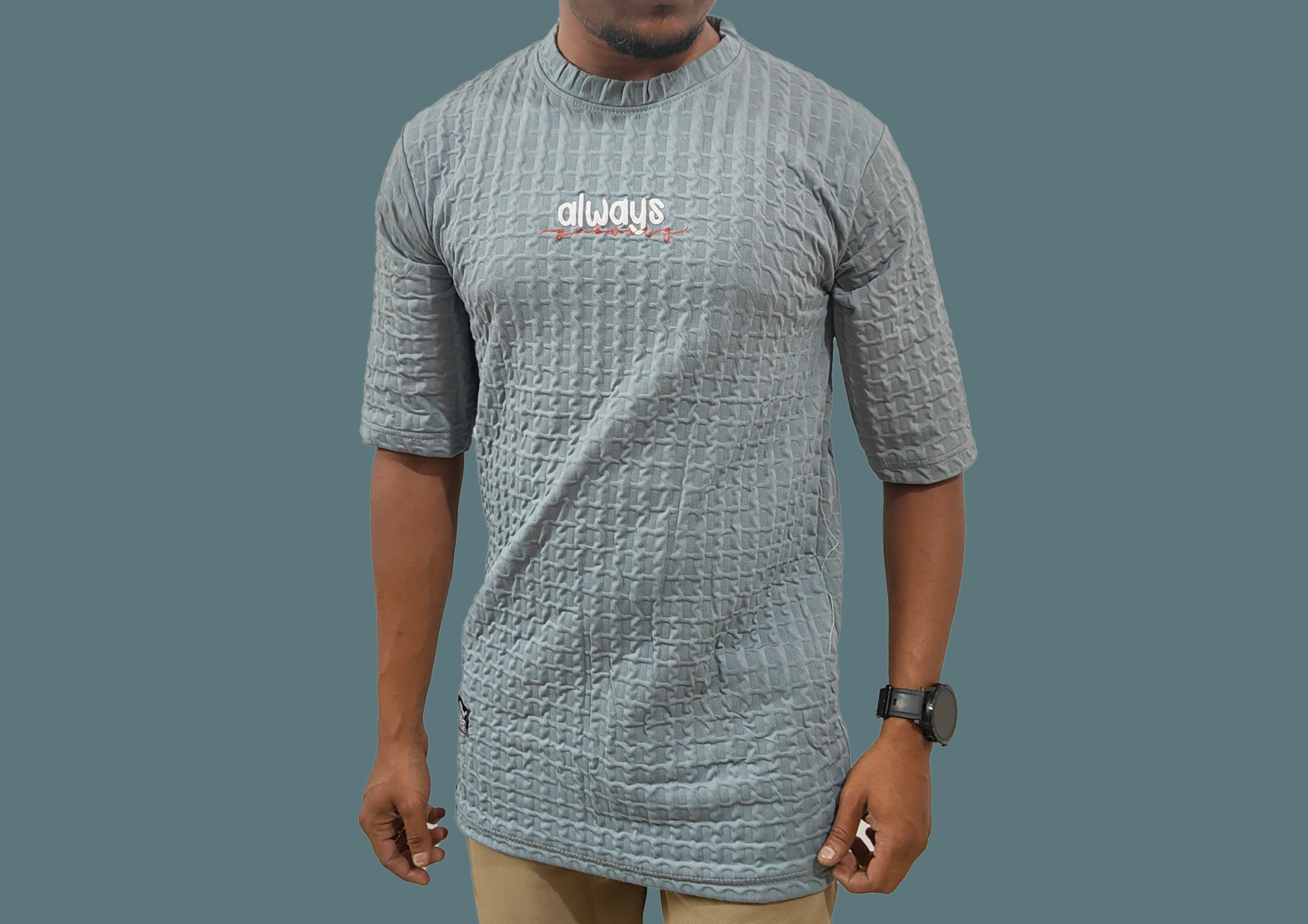 Person wearing a textured gray t-shirt with 'always' text on a plain background