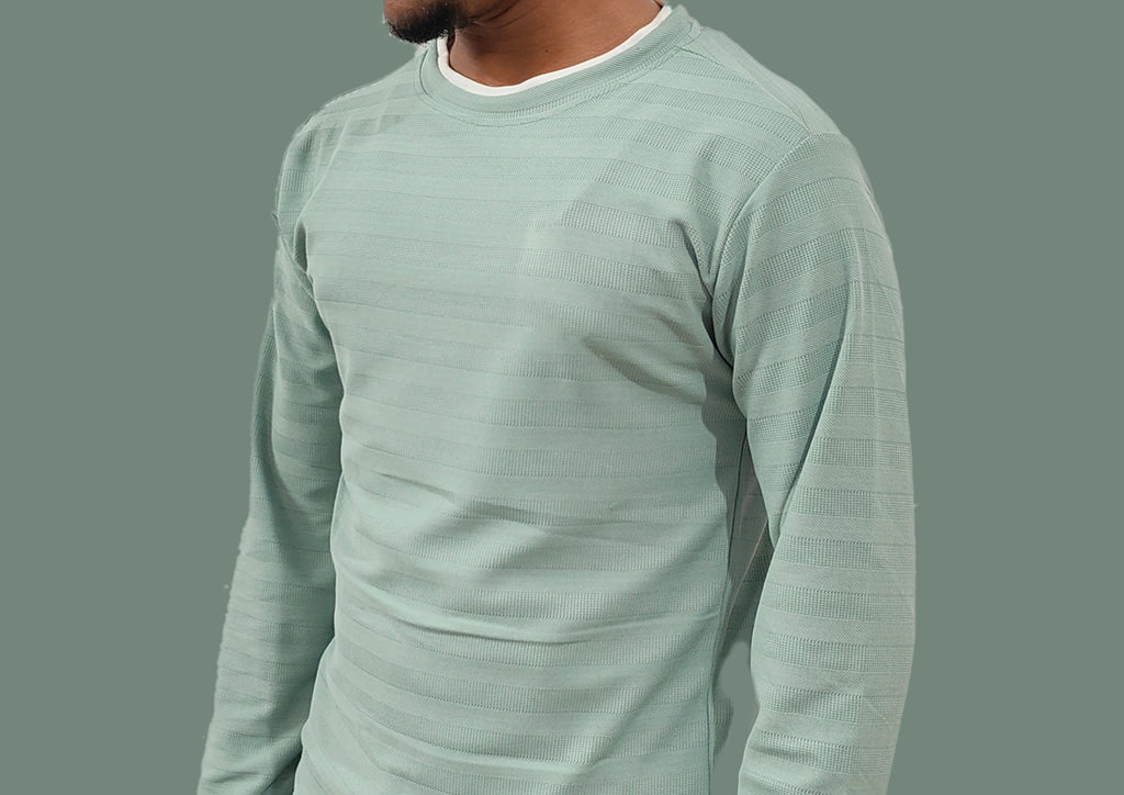 Light green long-sleeve shirt worn by a person on a gray background