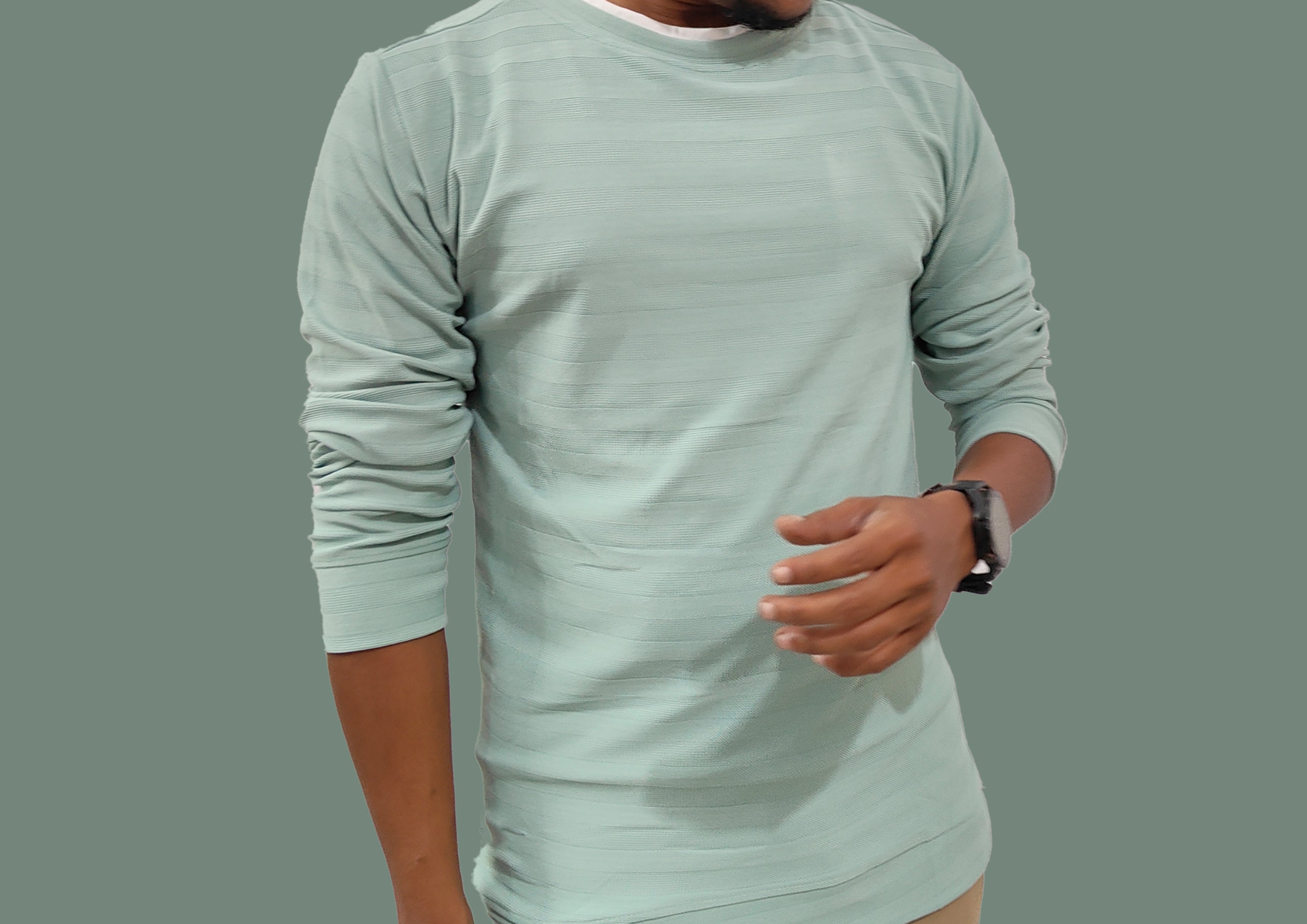 Person wearing a light green long-sleeve shirt on a gray background