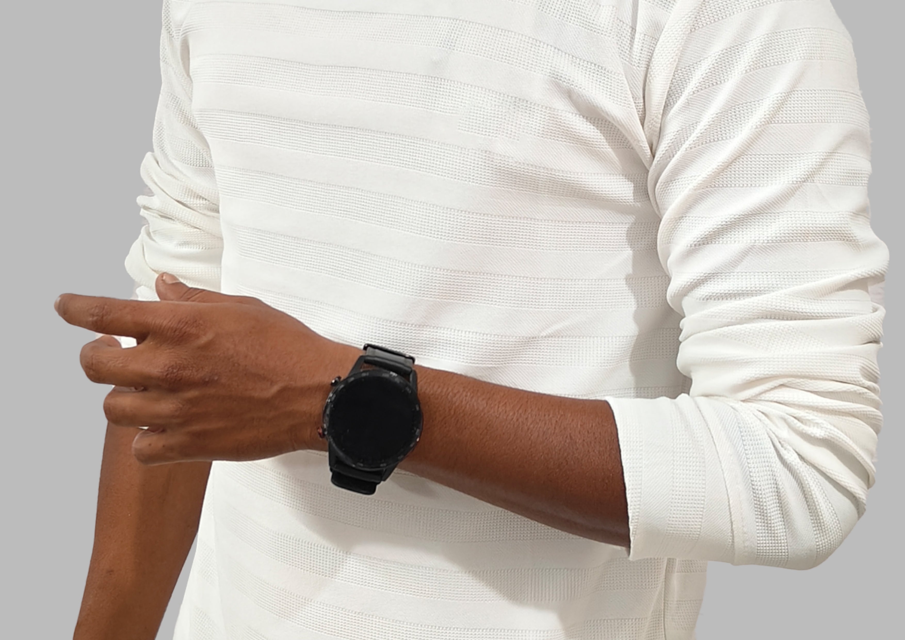 Person wearing a black smartwatch on a plain background