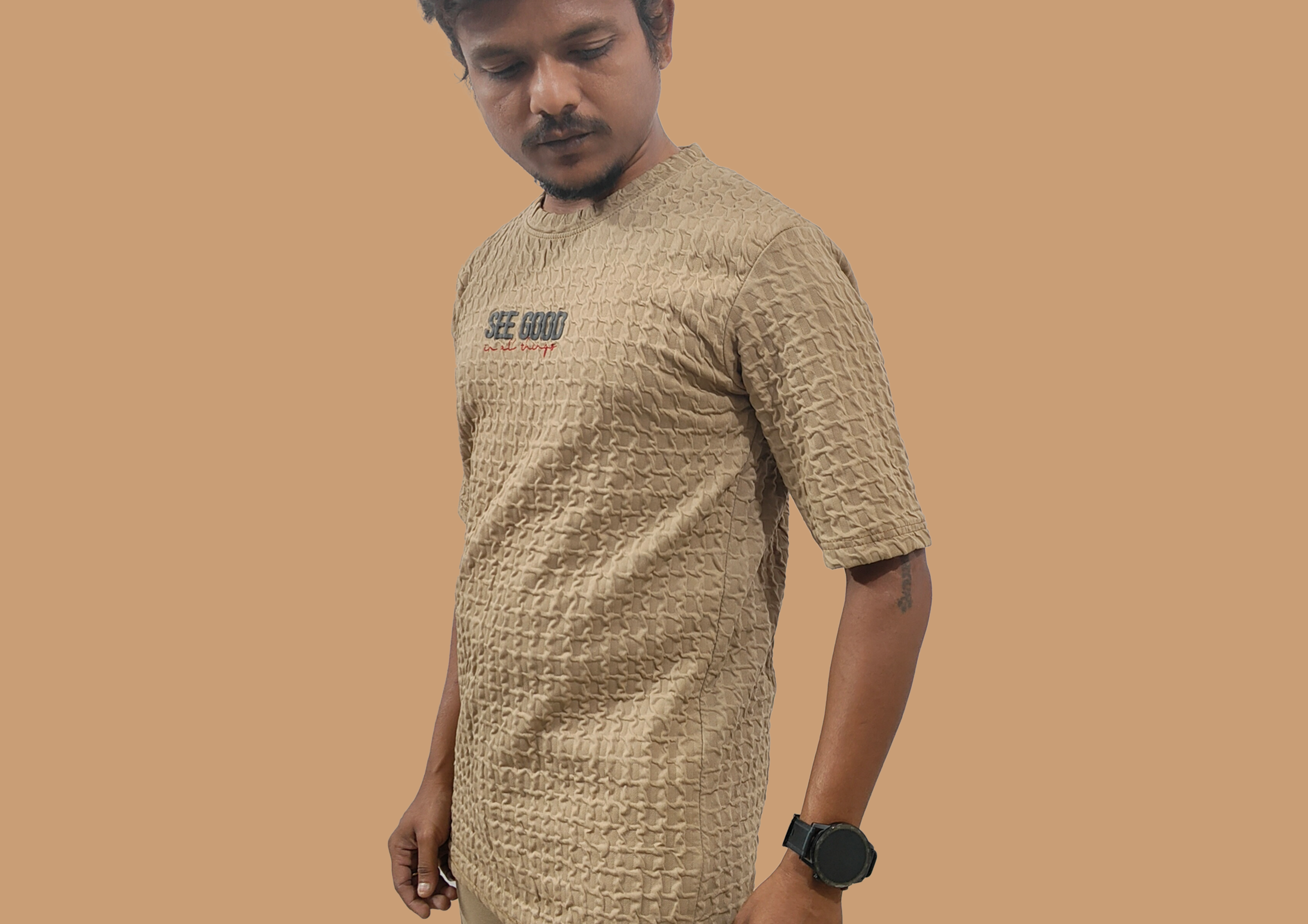 Man wearing a patterned beige shirt on a brown background