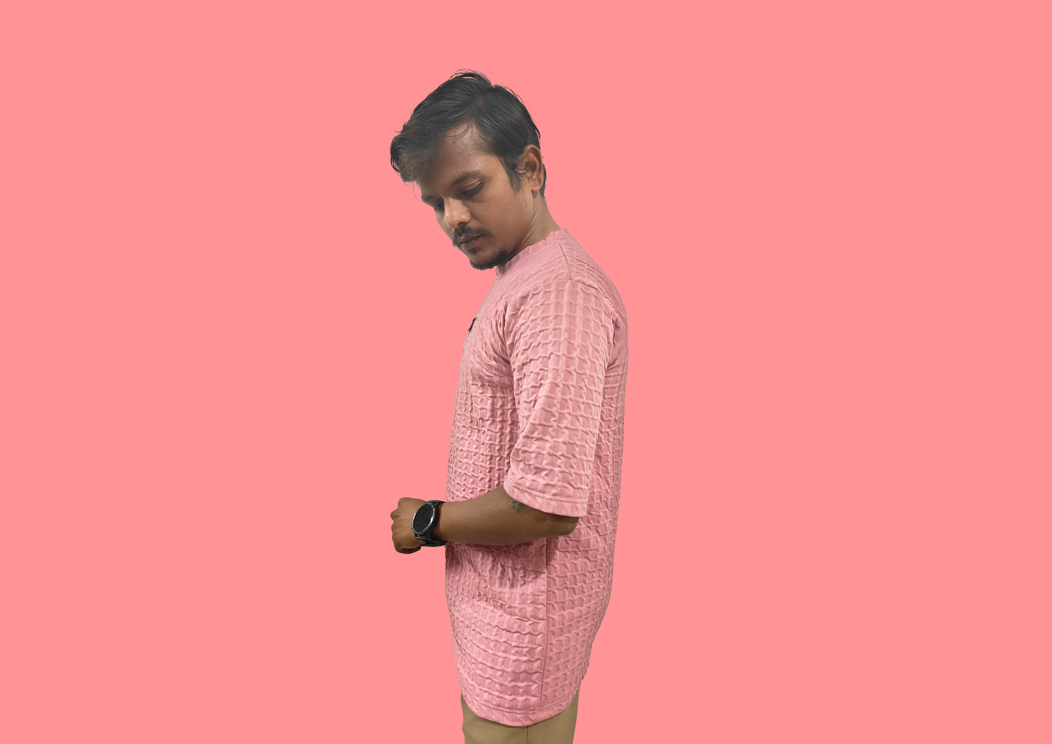 Man wearing a pink shirt against a pink background